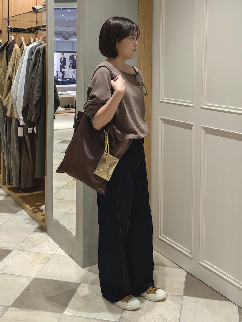 ブラウン系のスウェット、ブルー系のデニムパンツを着用したレディースの秋コーディネートの2枚目の写真