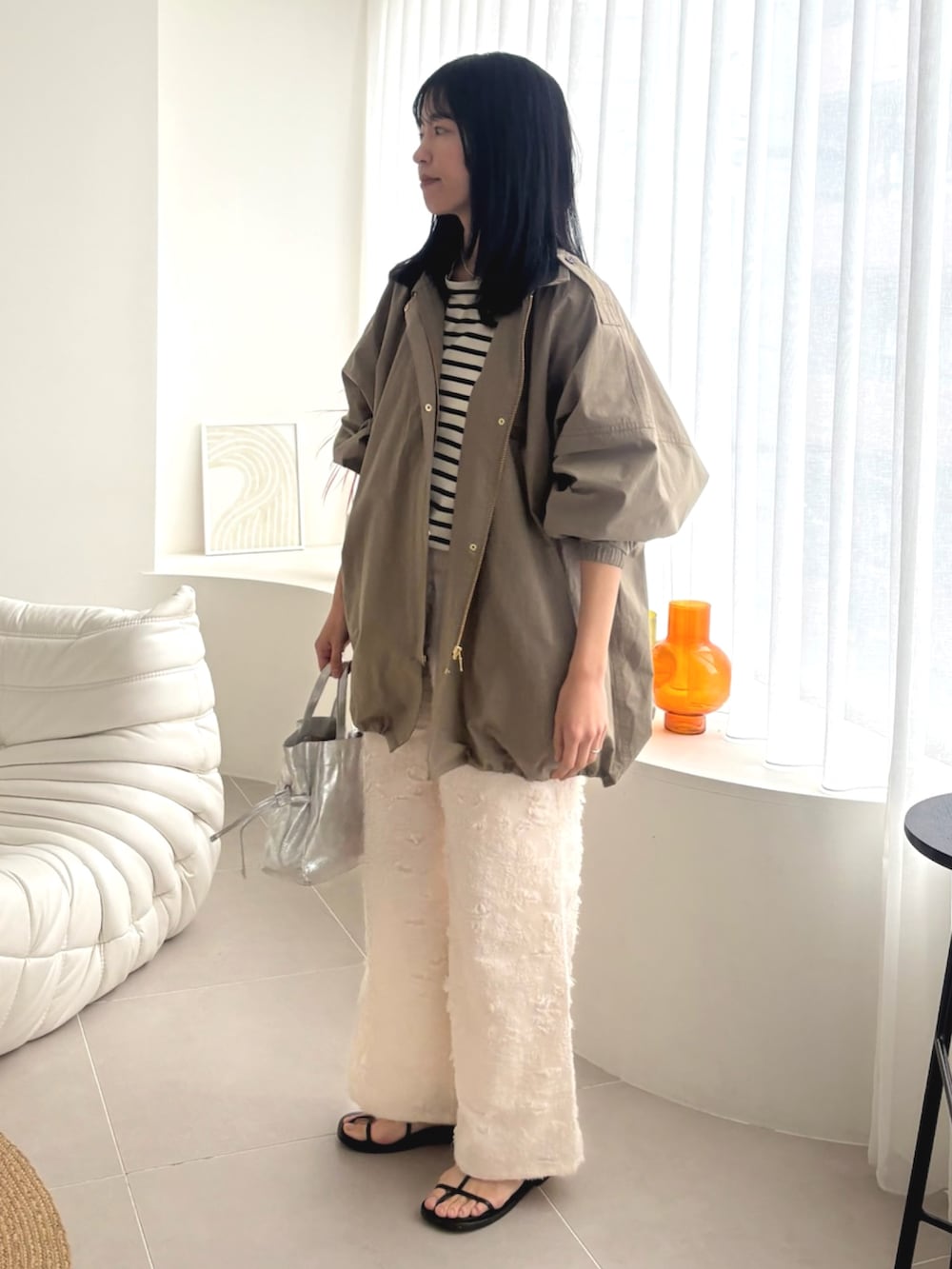 グリーン系のモッズコート、ホワイト系のその他パンツを着用したレディースの春コーディネートの2枚目の写真