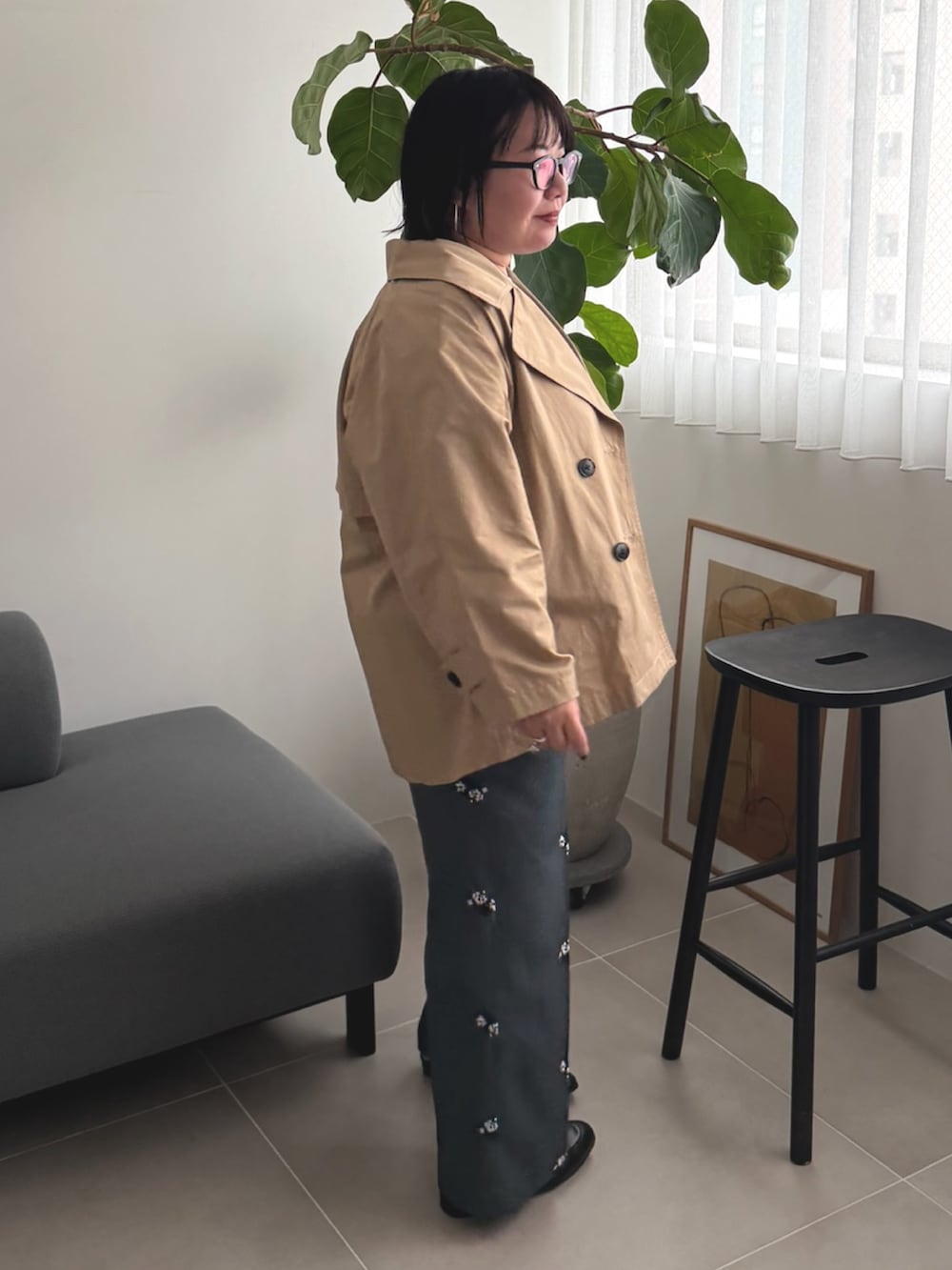 ベージュ系のトレンチコート、ブルー系のニット/セーター、グレー系のその他パンツを着用したレディースの春コーディネートの2枚目の写真