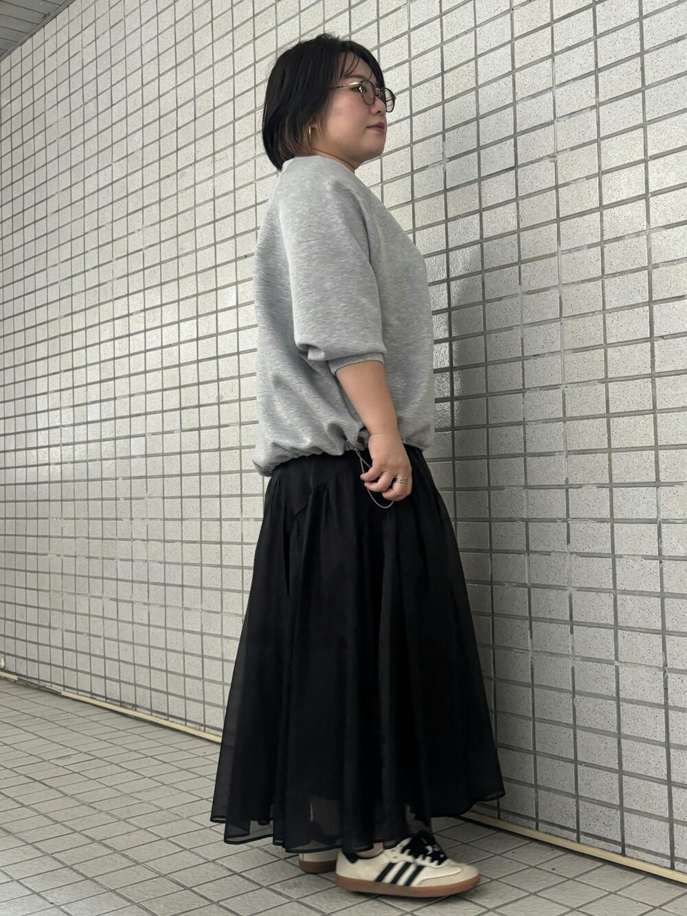 グレー系のTシャツ/カットソー、ブラック系のスカートを着用したレディースの秋コーディネートの2枚目の写真
