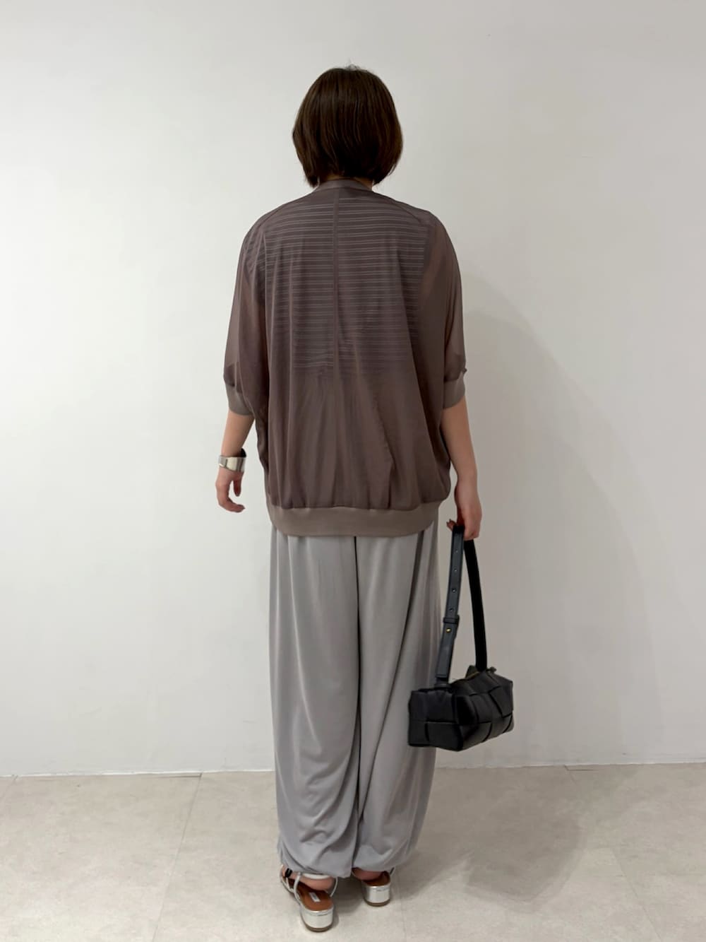 ブラウン系のカーディガン/ボレロ、グレー系のデニムパンツ、シルバー系のサンダルを着用したレディースの夏コーディネートの3枚目の写真