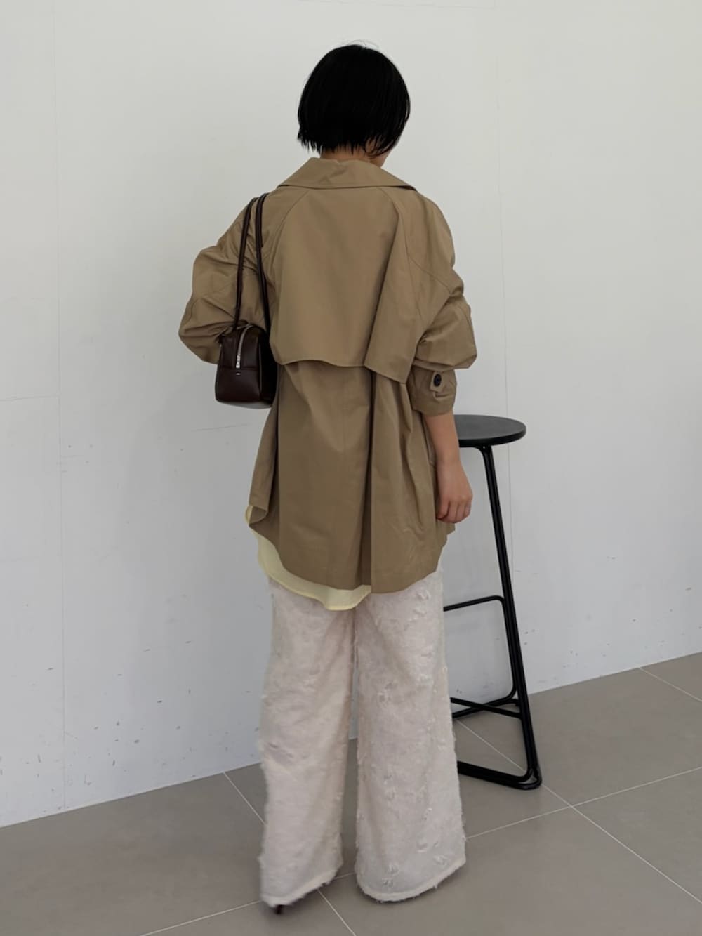 ベージュ系のトレンチコート、ホワイト系のその他パンツを着用したレディースの春コーディネートの3枚目の写真