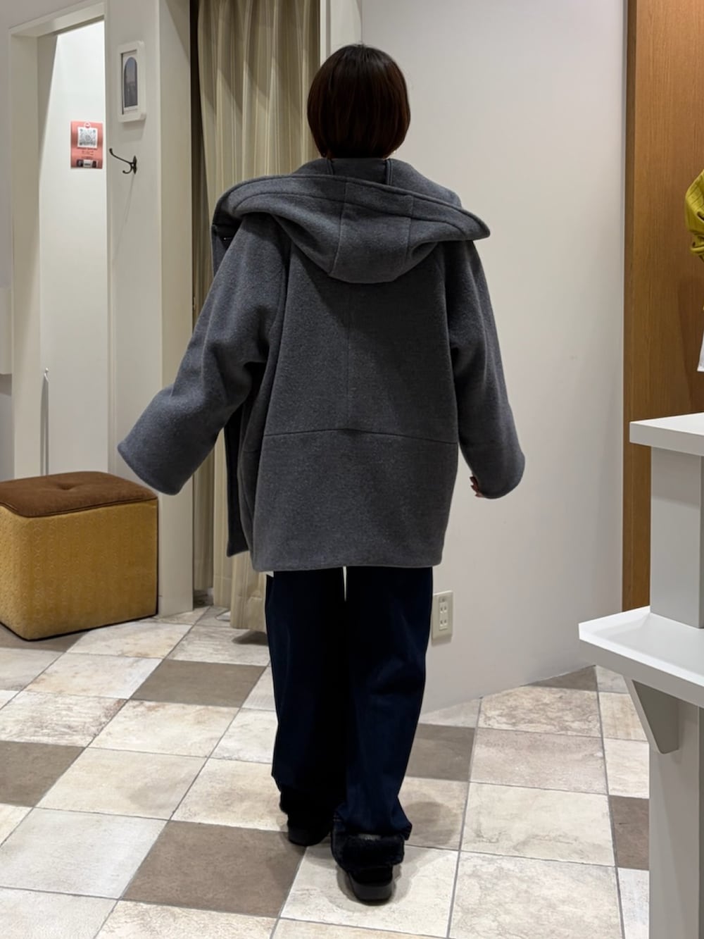 レッド系のニット/セーター、グレー系のその他アウター、ブルー系のデニムパンツを着用したレディースの冬コーディネートの3枚目の写真