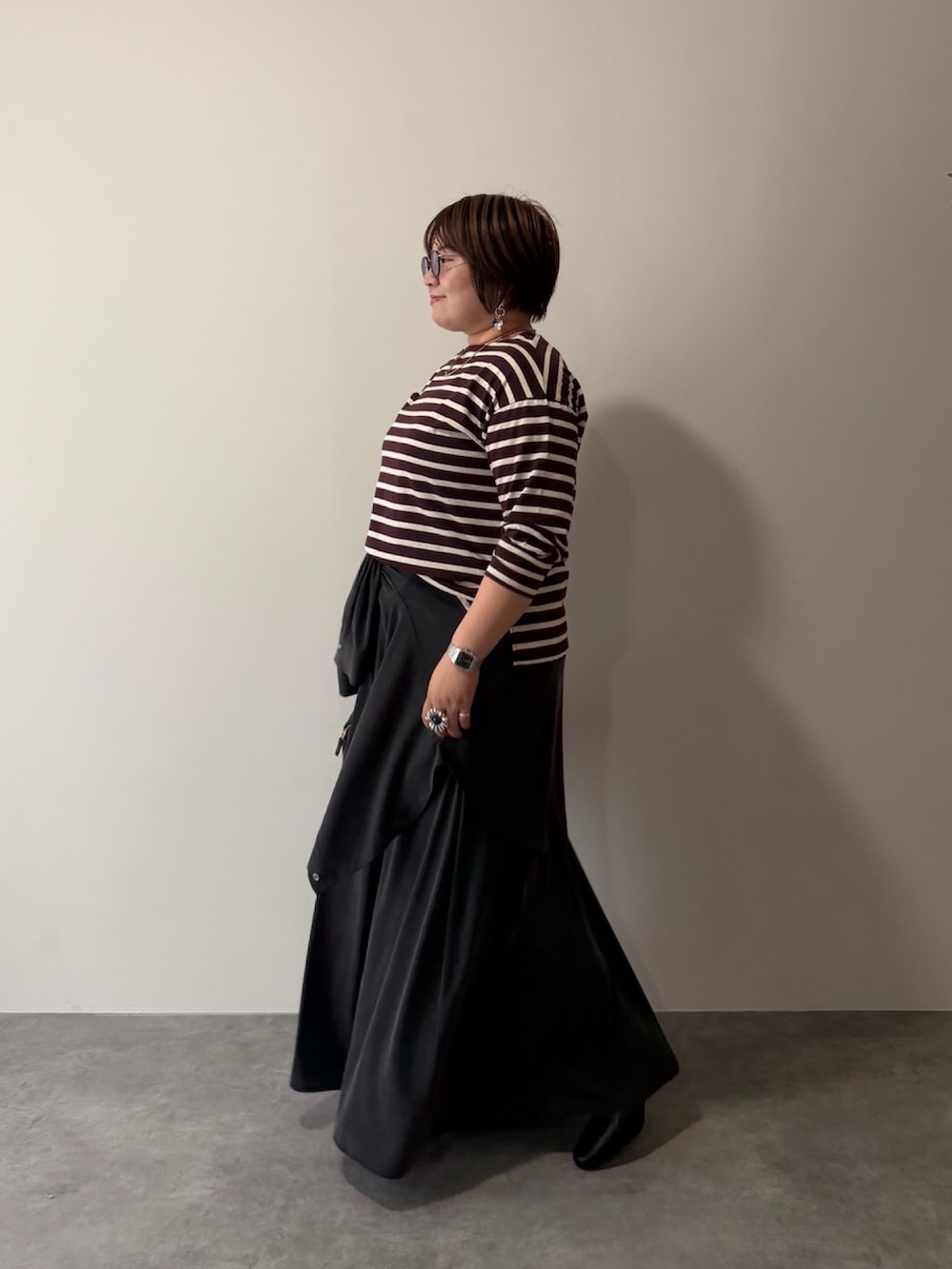 レッド系のTシャツ/カットソー、グレー系のシャツ/ブラウス、ブラック系のスカートを着用したレディースの秋コーディネートの2枚目の写真