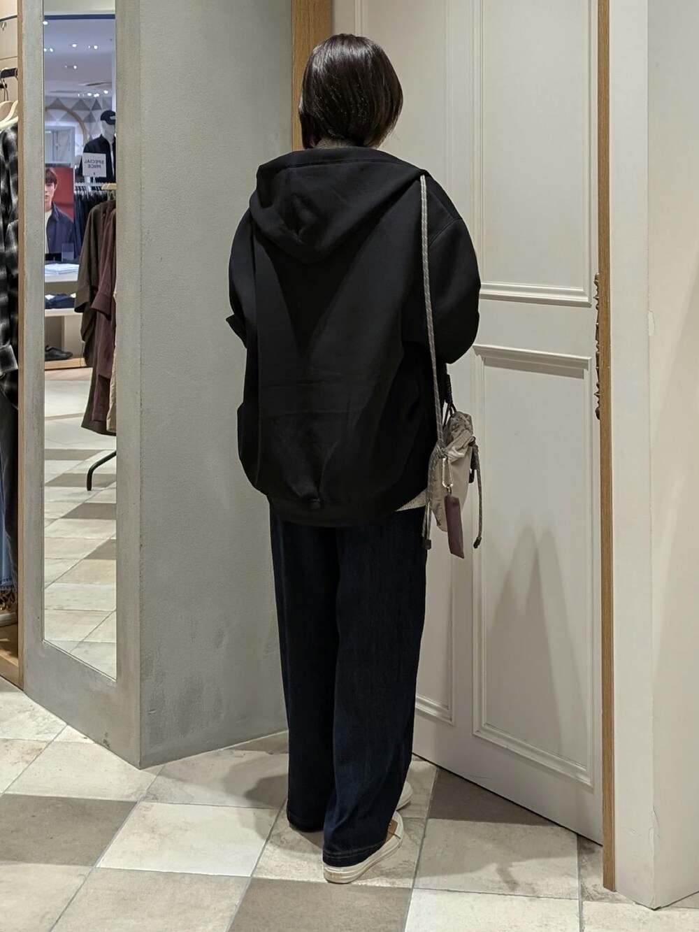 ブルー系のデニムパンツ、ブラック系のパーカーを着用したレディースの秋コーディネートの3枚目の写真