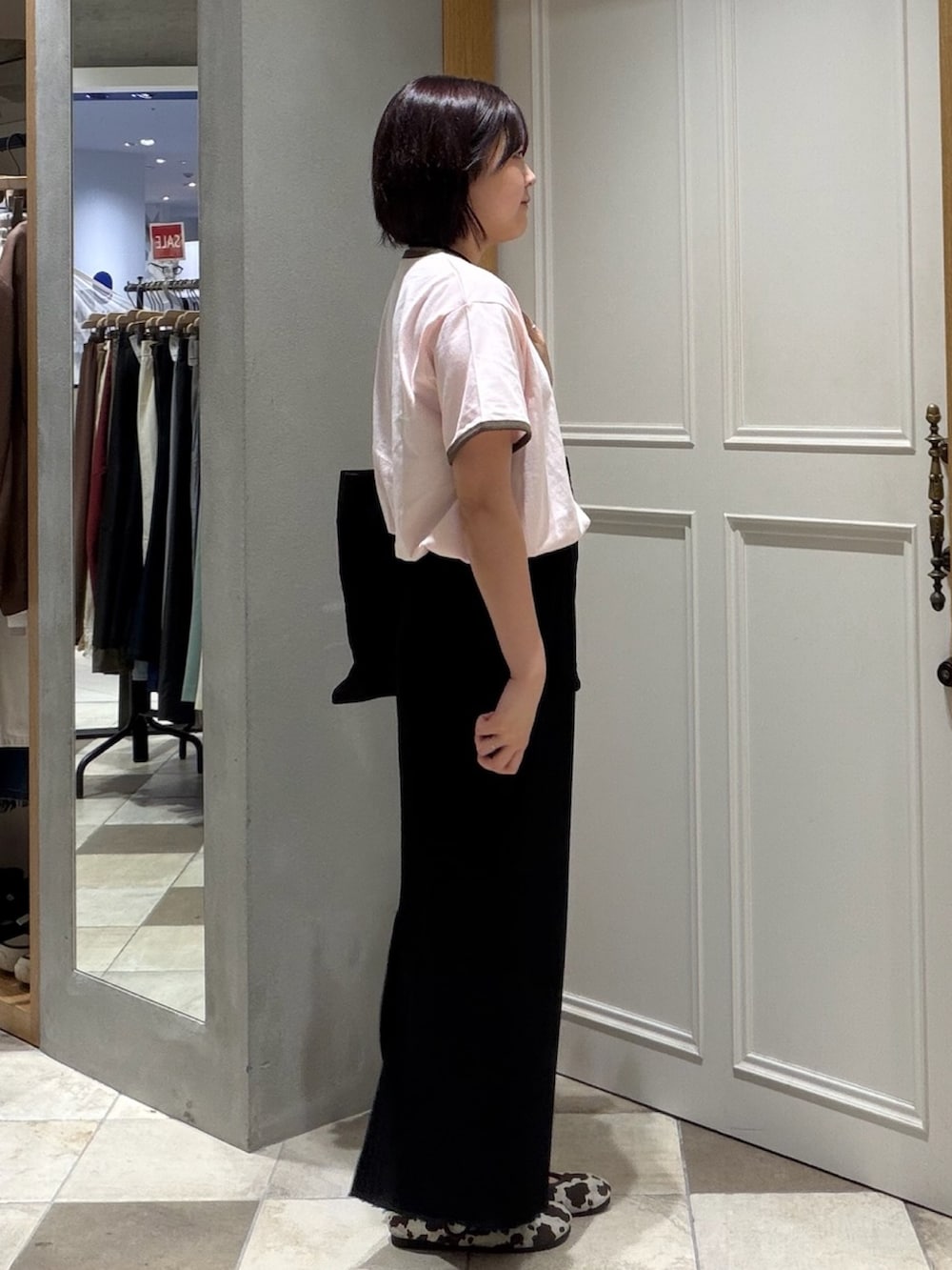 ピンク系のTシャツ/カットソー、ブラック系のスカート、ブラック系のトートバッグを着用したレディースの夏コーディネートの2枚目の写真