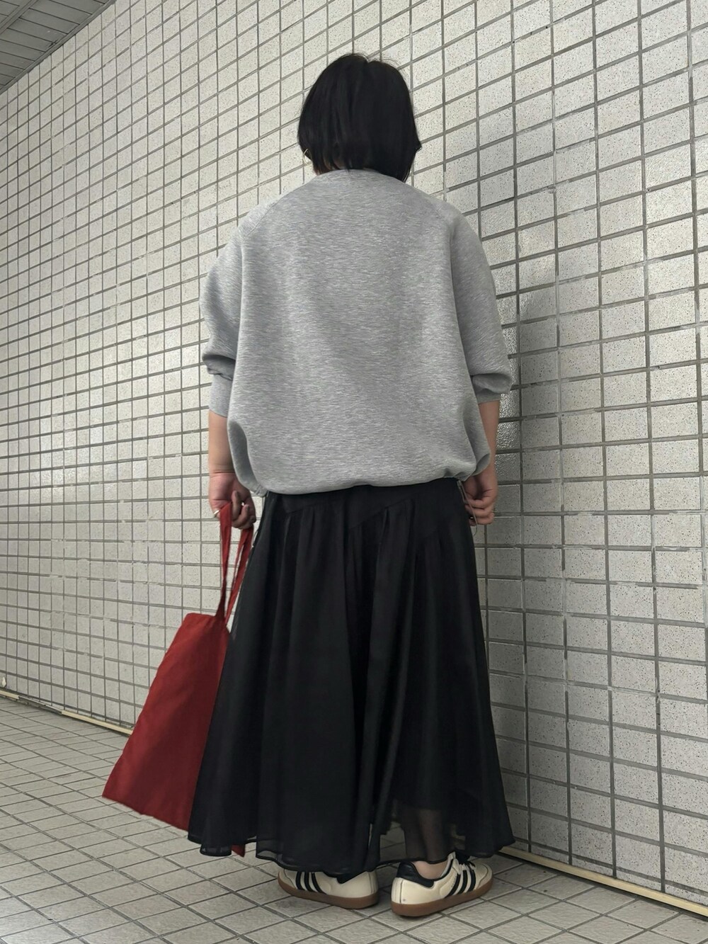 グレー系のTシャツ/カットソー、ブラック系のスカートを着用したレディースの秋コーディネートの3枚目の写真