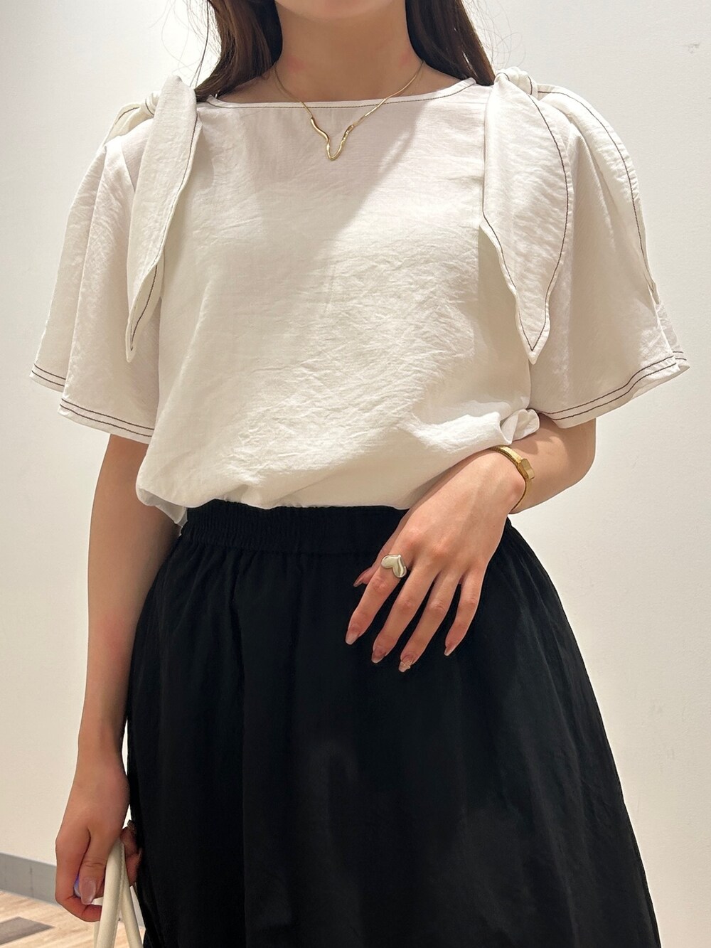 ホワイト系のシャツ/ブラウス、ブラック系のワンピース、ゴールド系のサンダルを着用したレディースの夏コーディネートの2枚目の写真