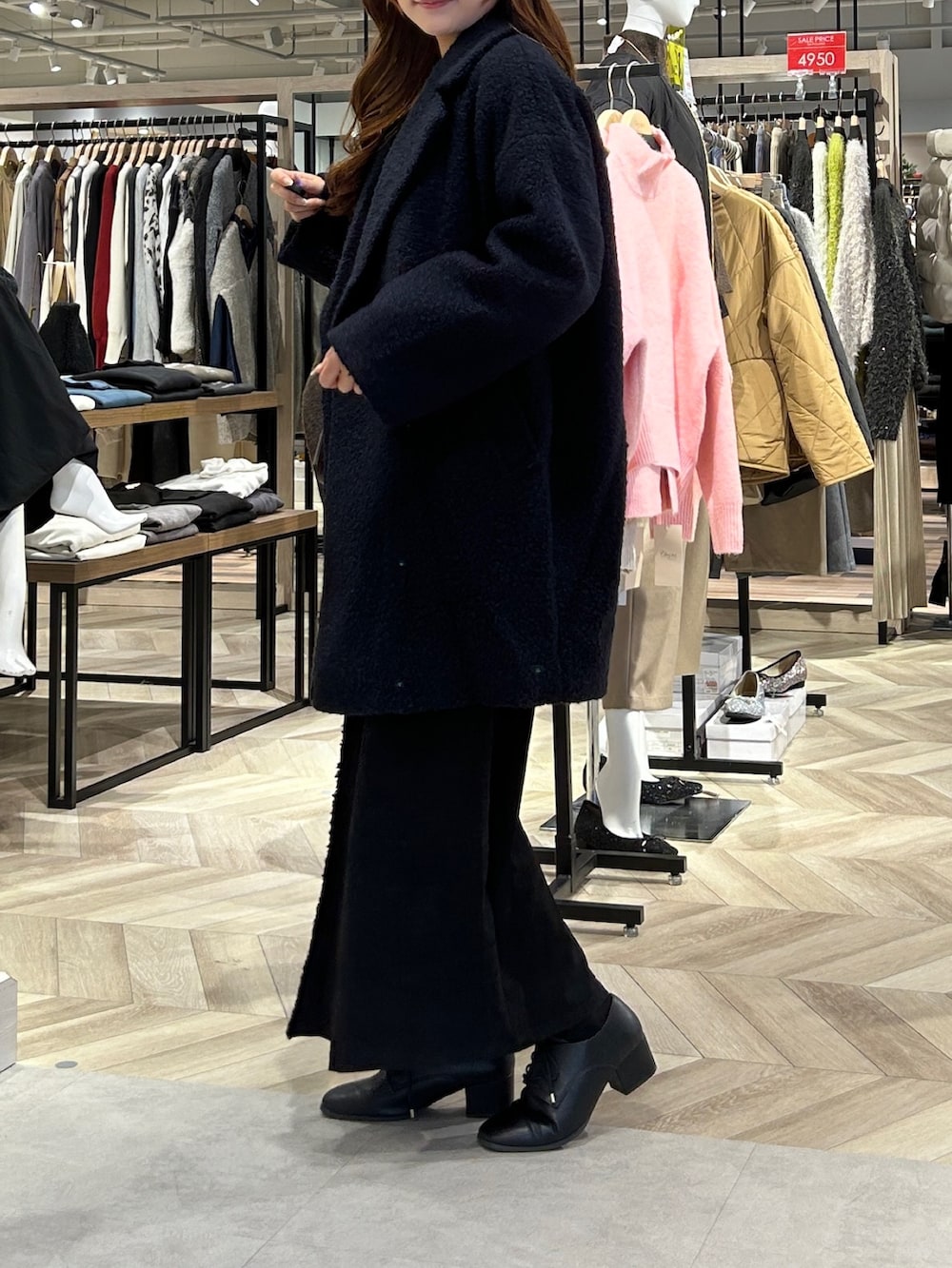 ブルー系のその他アウター、ホワイト系のニット/セーター、グレー系のスカートを着用したレディースの冬コーディネートの2枚目の写真