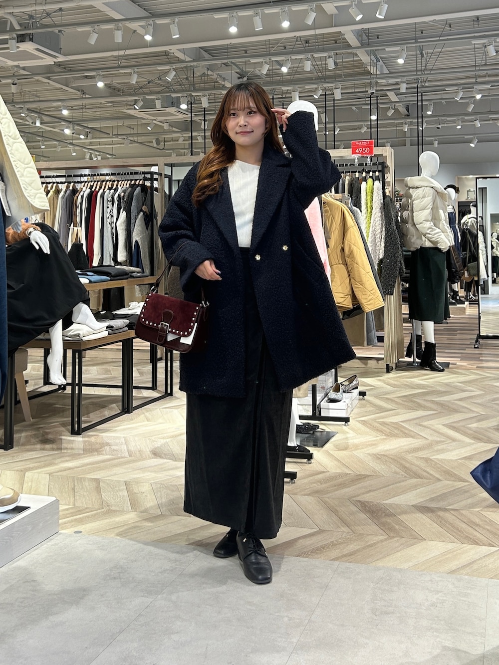 ブルー系のその他アウター、ホワイト系のニット/セーター、グレー系のスカートを着用したレディースの冬コーディネートの5枚目の写真