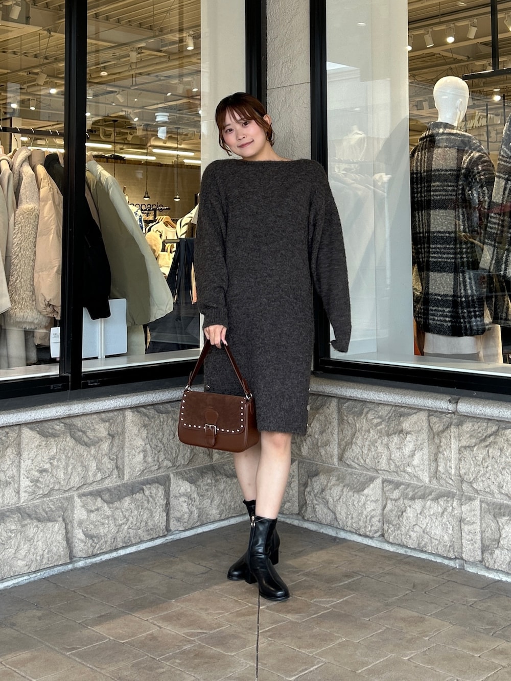 ブラウン系のチュニック、ブラック系のブーツを着用したレディースの冬コーディネートの4枚目の写真