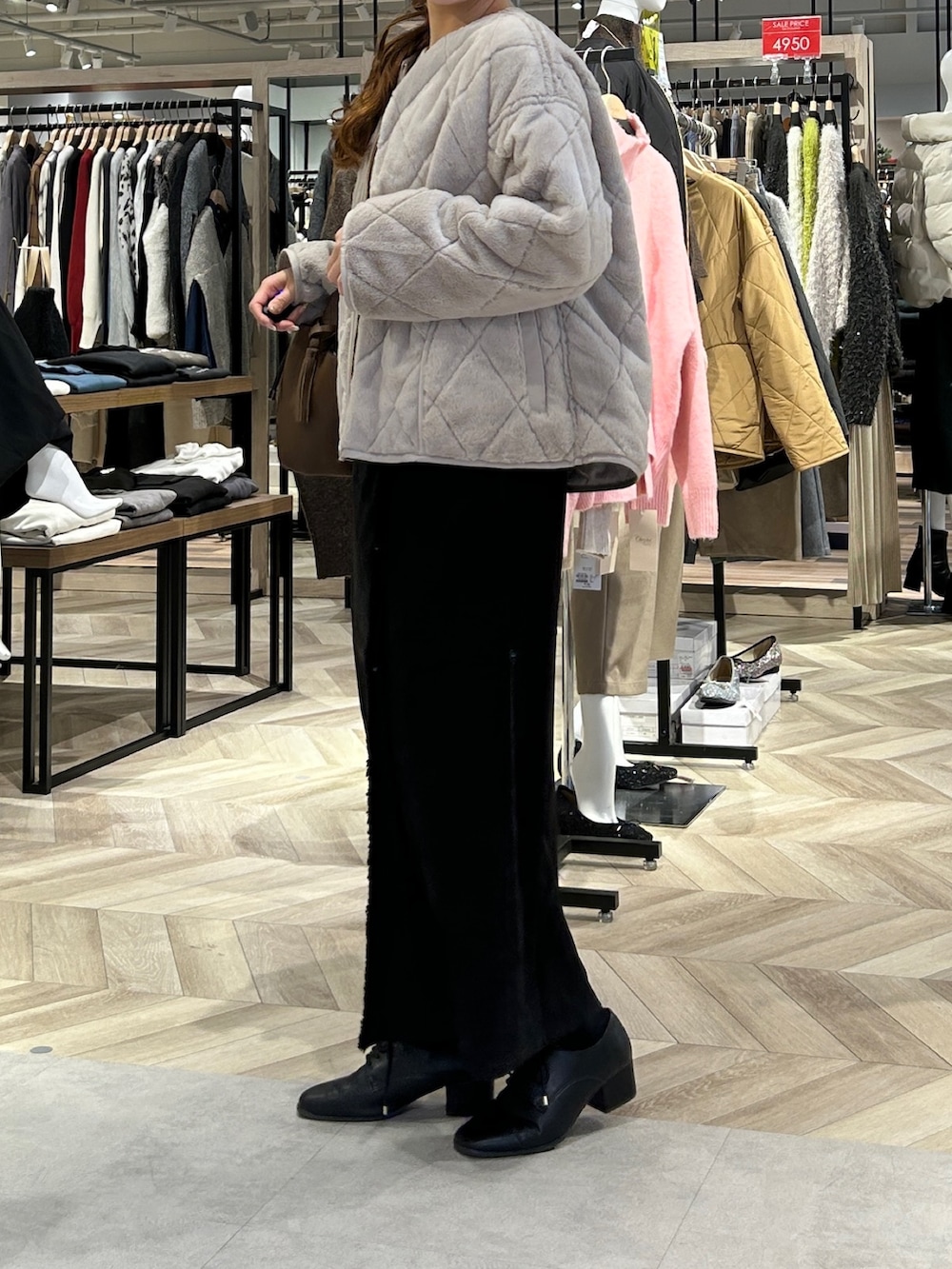 ホワイト系のニット/セーター、ベージュ系のブルゾン、グレー系のスカートを着用したレディースの冬コーディネートの2枚目の写真