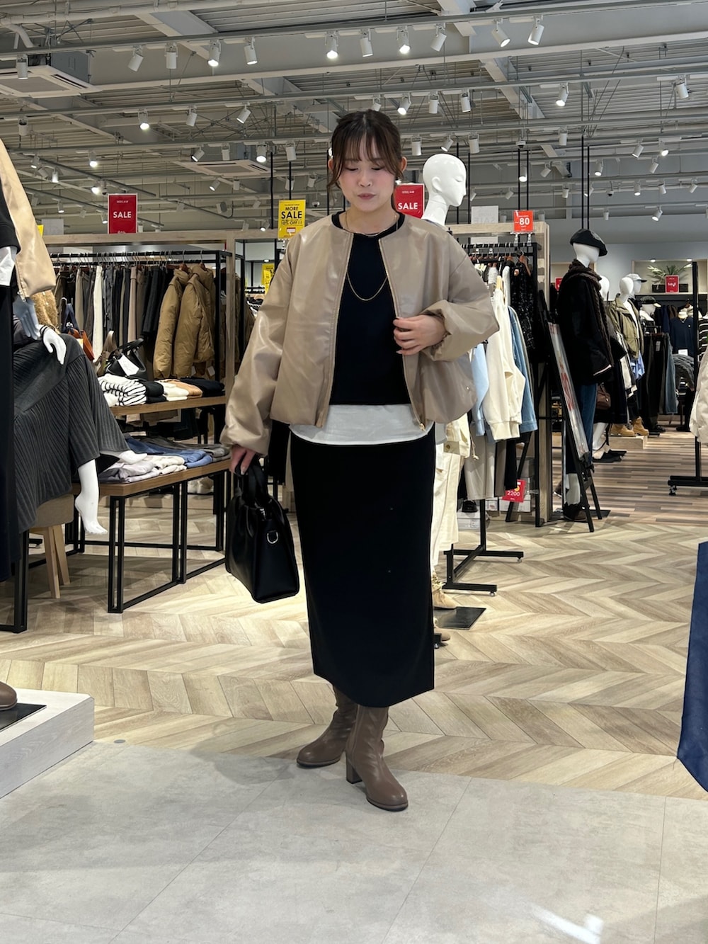 ブラック系のつなぎ/オールインワン、ブラック系のショルダーバッグ、ブラウン系のブーツを着用したレディースの冬コーディネートの4枚目の写真