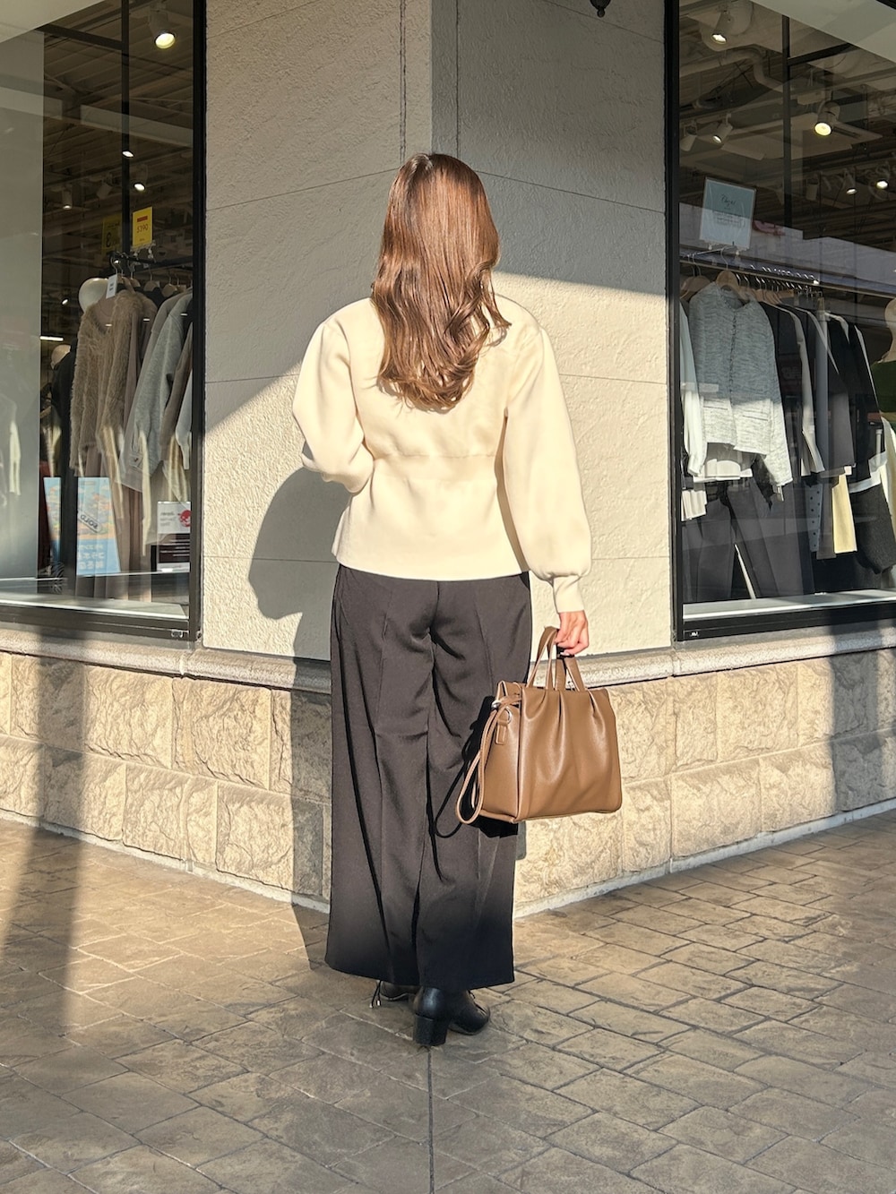 ブラック系のブーツ、ブラウン系のショルダーバッグ、ブラック系のその他パンツを着用したレディースの冬コーディネートの4枚目の写真