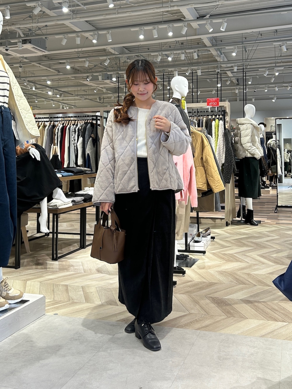 ホワイト系のニット/セーター、ベージュ系のブルゾン、グレー系のスカートを着用したレディースの冬コーディネートの4枚目の写真