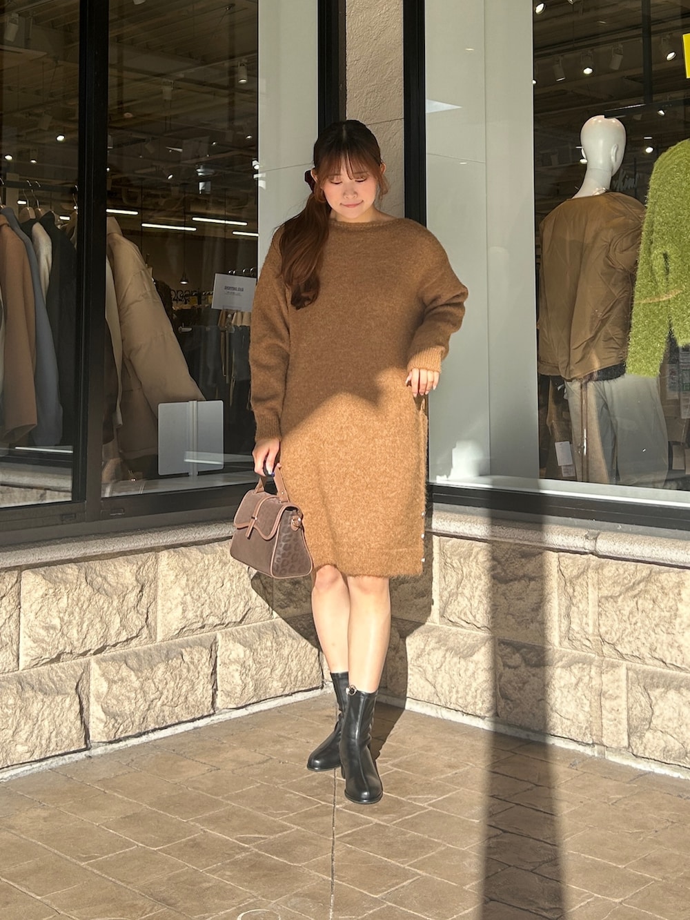 ベージュ系のチュニック、ブラック系のブーツを着用したレディースの冬コーディネートの4枚目の写真