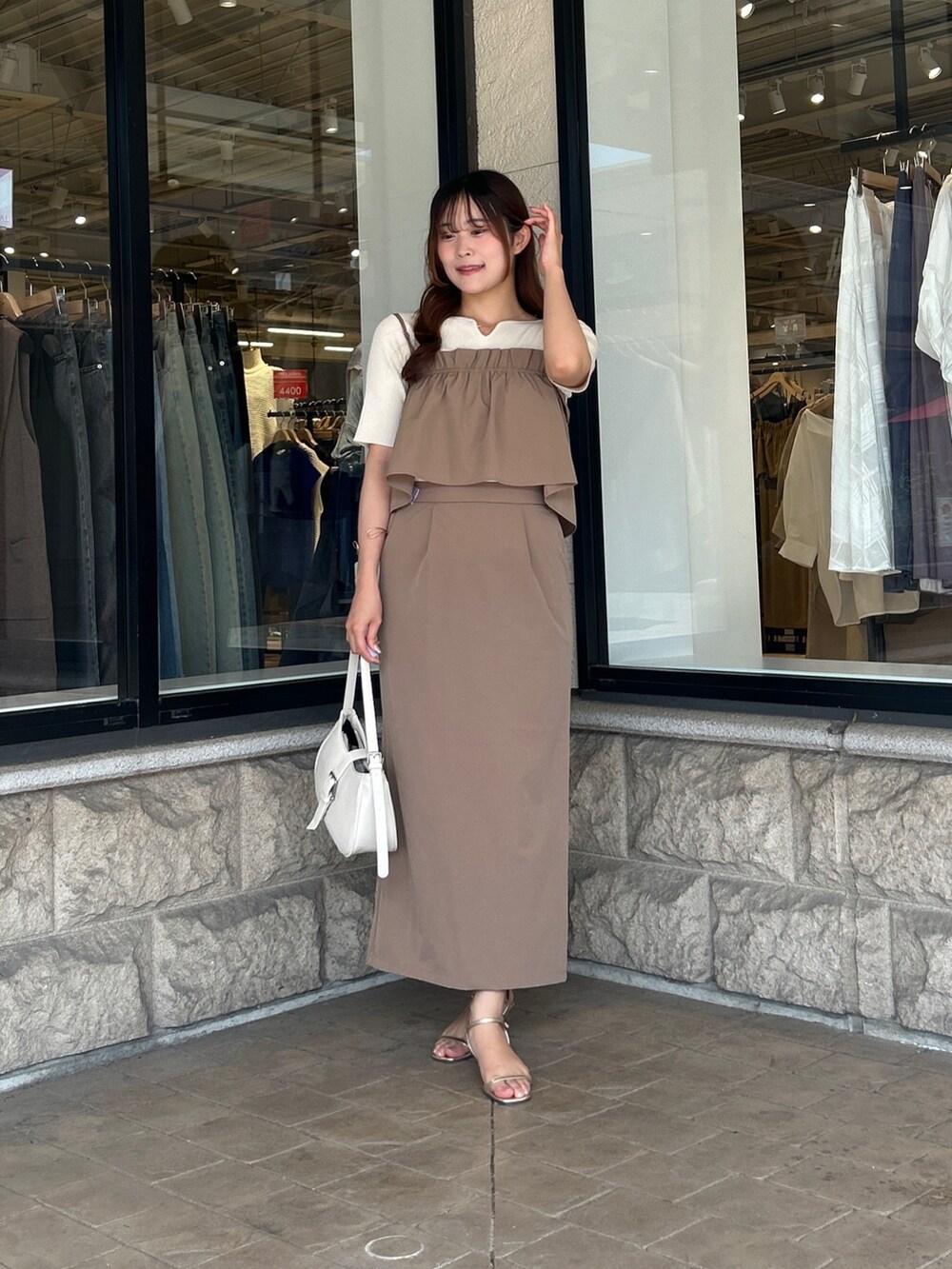 ベージュ系のスカート、ホワイト系のニット/セーター、ゴールド系のサンダルを着用したレディースの夏コーディネートの4枚目の写真