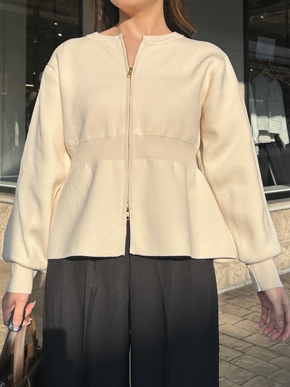 ブラック系のブーツ、ブラウン系のショルダーバッグ、ブラック系のその他パンツを着用したレディースの冬コーディネートの2枚目の写真