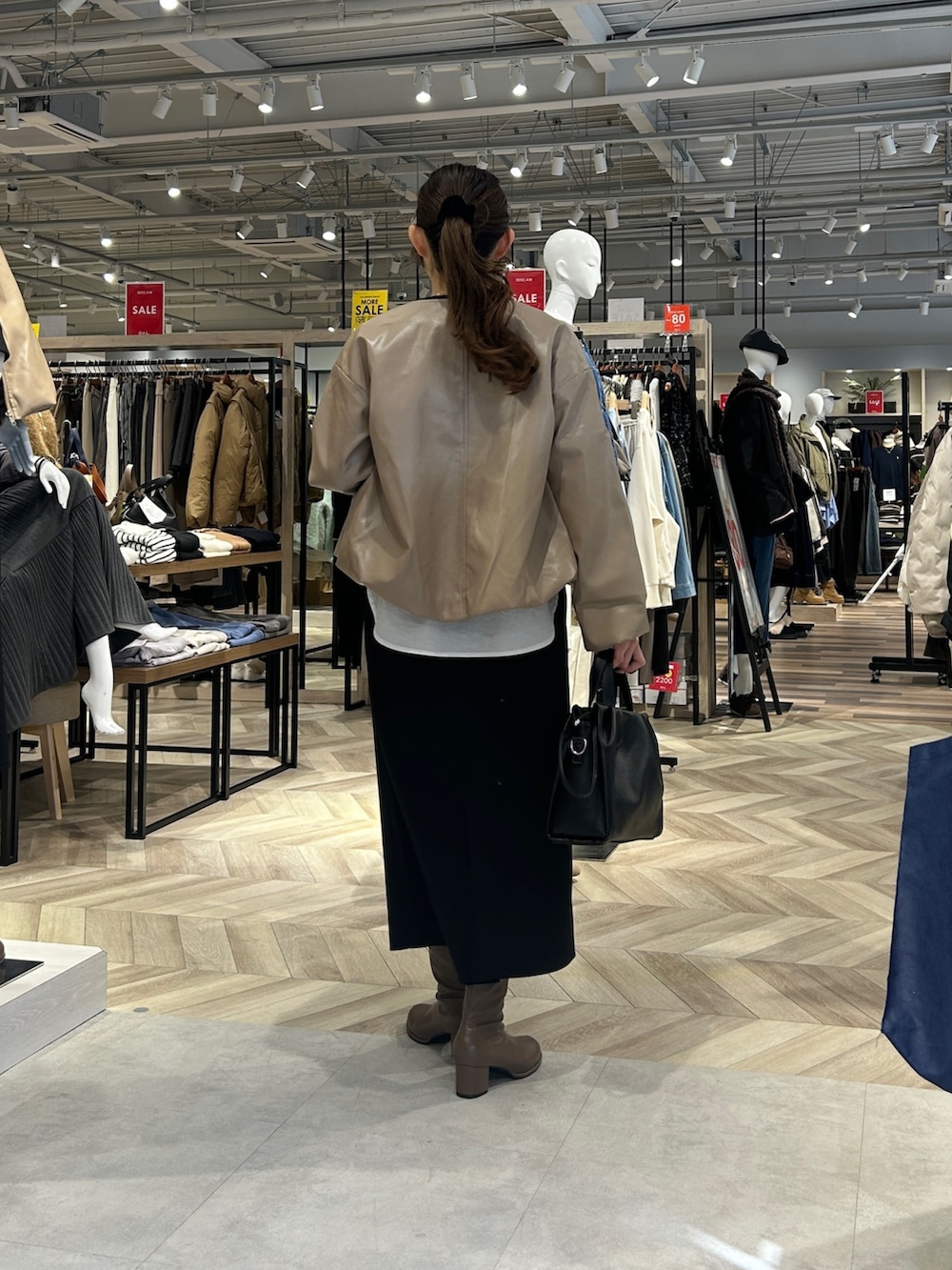 ブラック系のつなぎ/オールインワン、ブラック系のショルダーバッグ、ブラウン系のブーツを着用したレディースの冬コーディネートの3枚目の写真