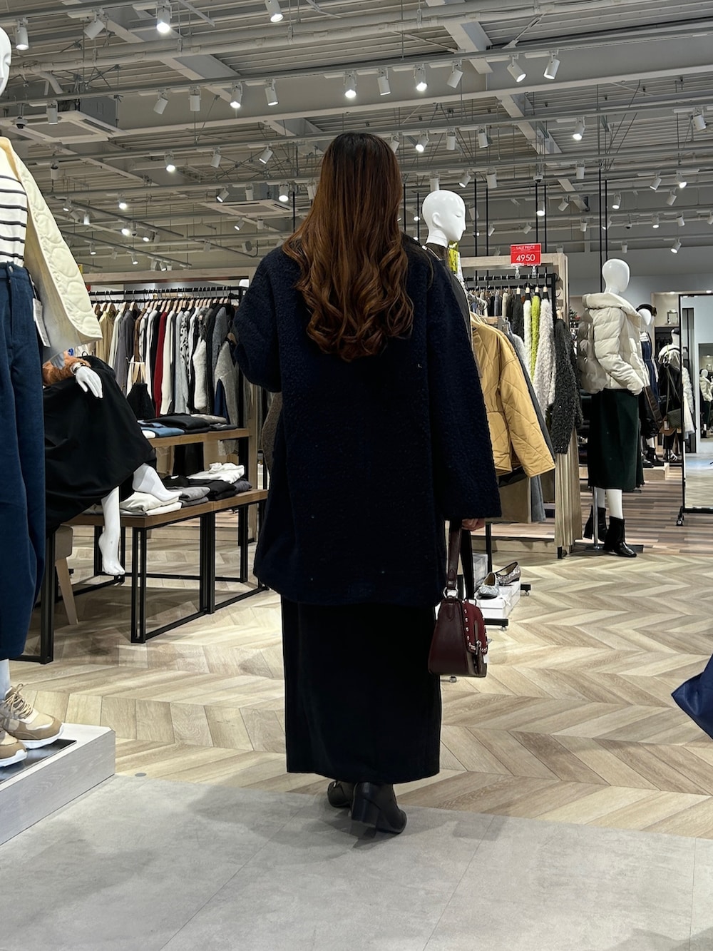 ブルー系のその他アウター、ホワイト系のニット/セーター、グレー系のスカートを着用したレディースの冬コーディネートの3枚目の写真