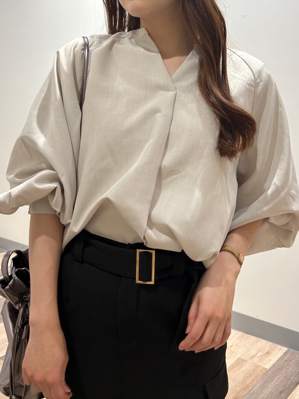 グレー系のシャツ/ブラウス、ブラック系のスカート、シルバー系のパンプスを着用したレディースの春コーディネートの2枚目の写真