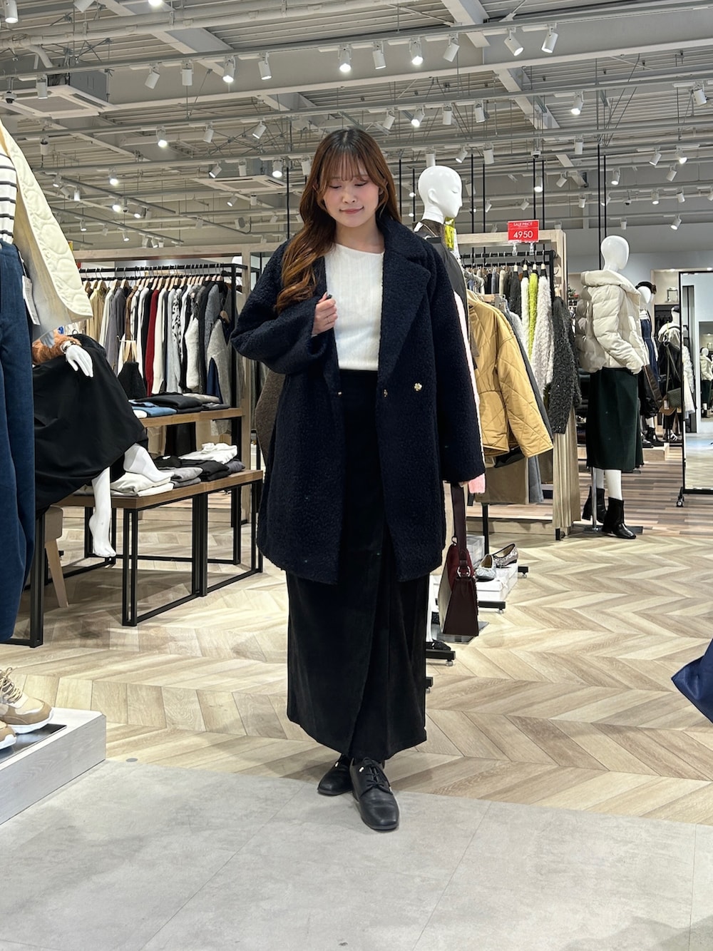 ブルー系のその他アウター、ホワイト系のニット/セーター、グレー系のスカートを着用したレディースの冬コーディネートの4枚目の写真