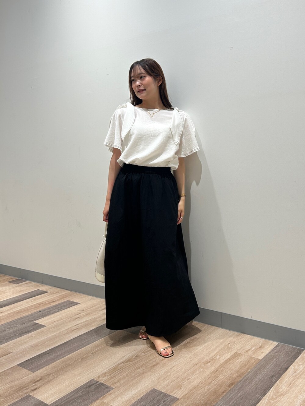 ホワイト系のシャツ/ブラウス、ブラック系のワンピース、ゴールド系のサンダルを着用したレディースの夏コーディネートの4枚目の写真