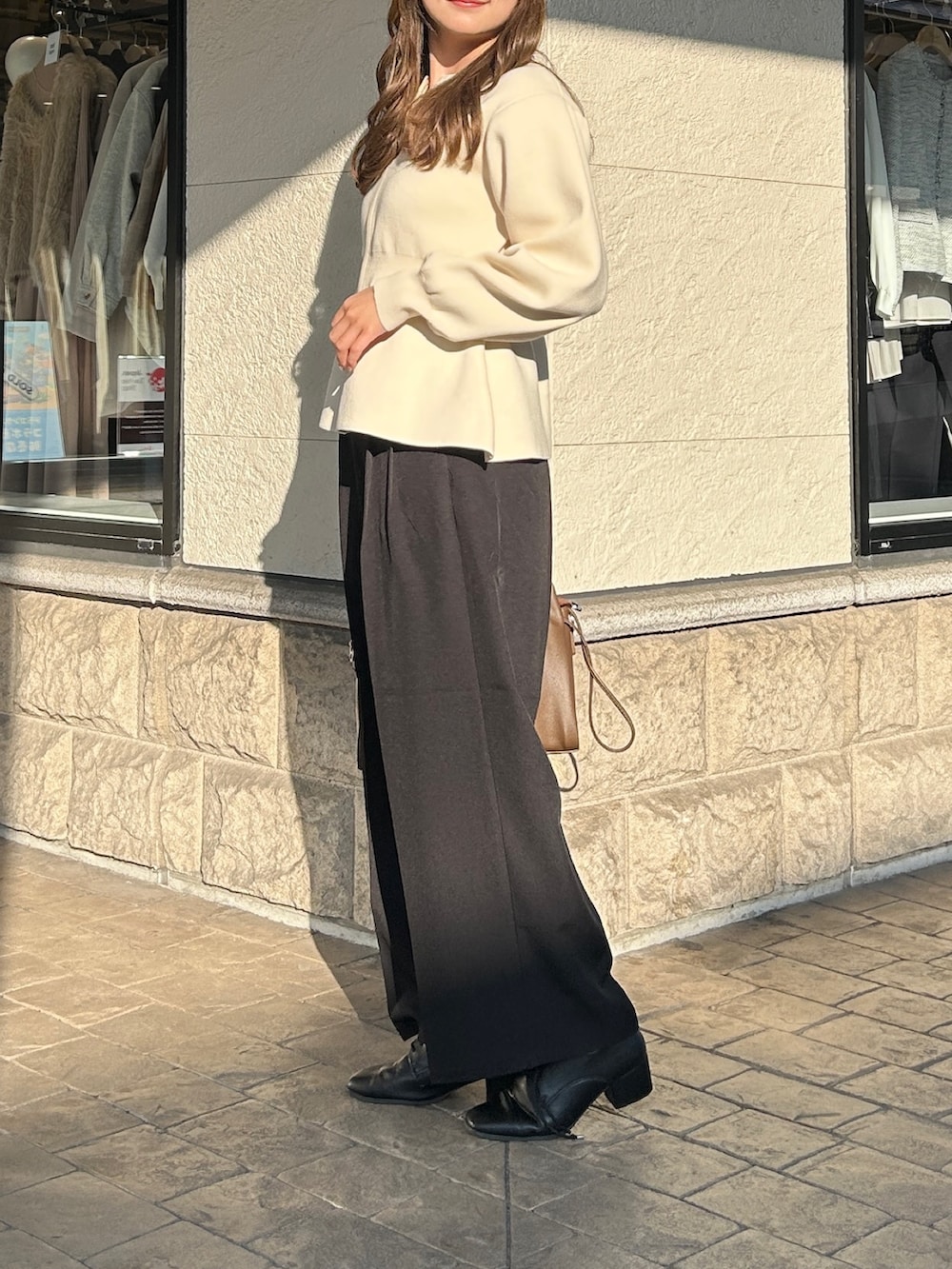 ブラック系のブーツ、ブラウン系のショルダーバッグ、ブラック系のその他パンツを着用したレディースの冬コーディネートの3枚目の写真