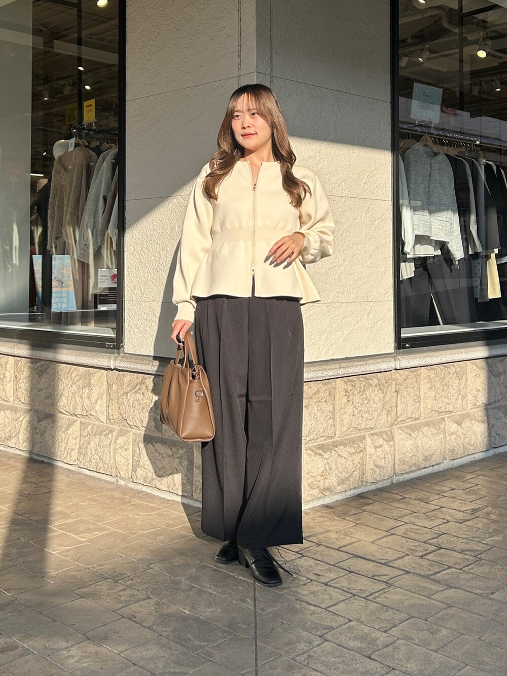 ブラック系のブーツ、ブラウン系のショルダーバッグ、ブラック系のその他パンツを着用したレディースの冬コーディネートの6枚目の写真