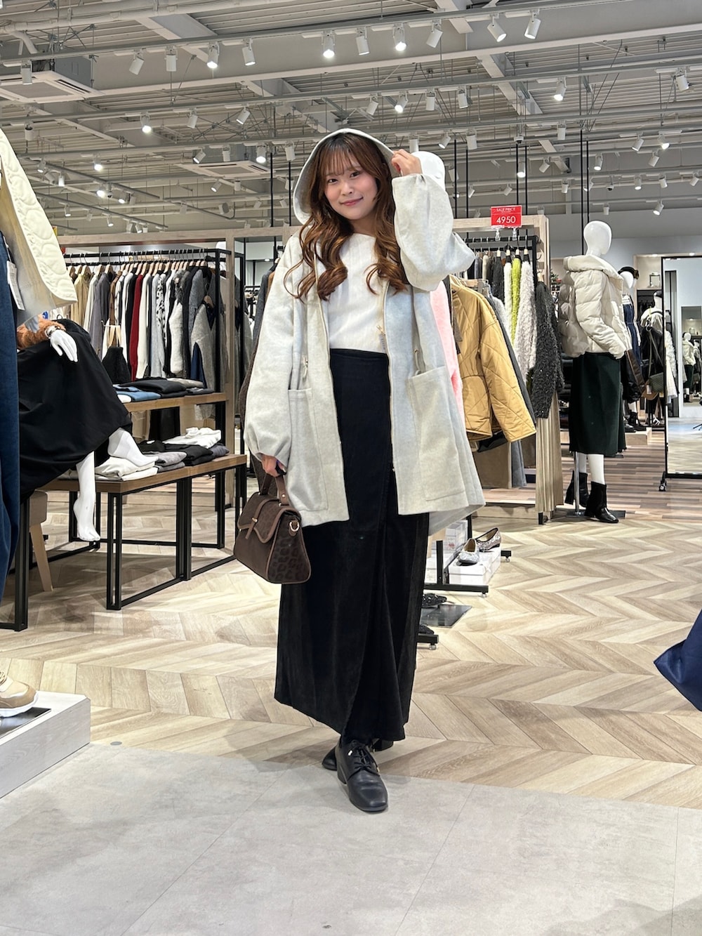 ホワイト系のニット/セーター、グレー系のスカート、ブラック系のブーツを着用したレディースの冬コーディネートの4枚目の写真