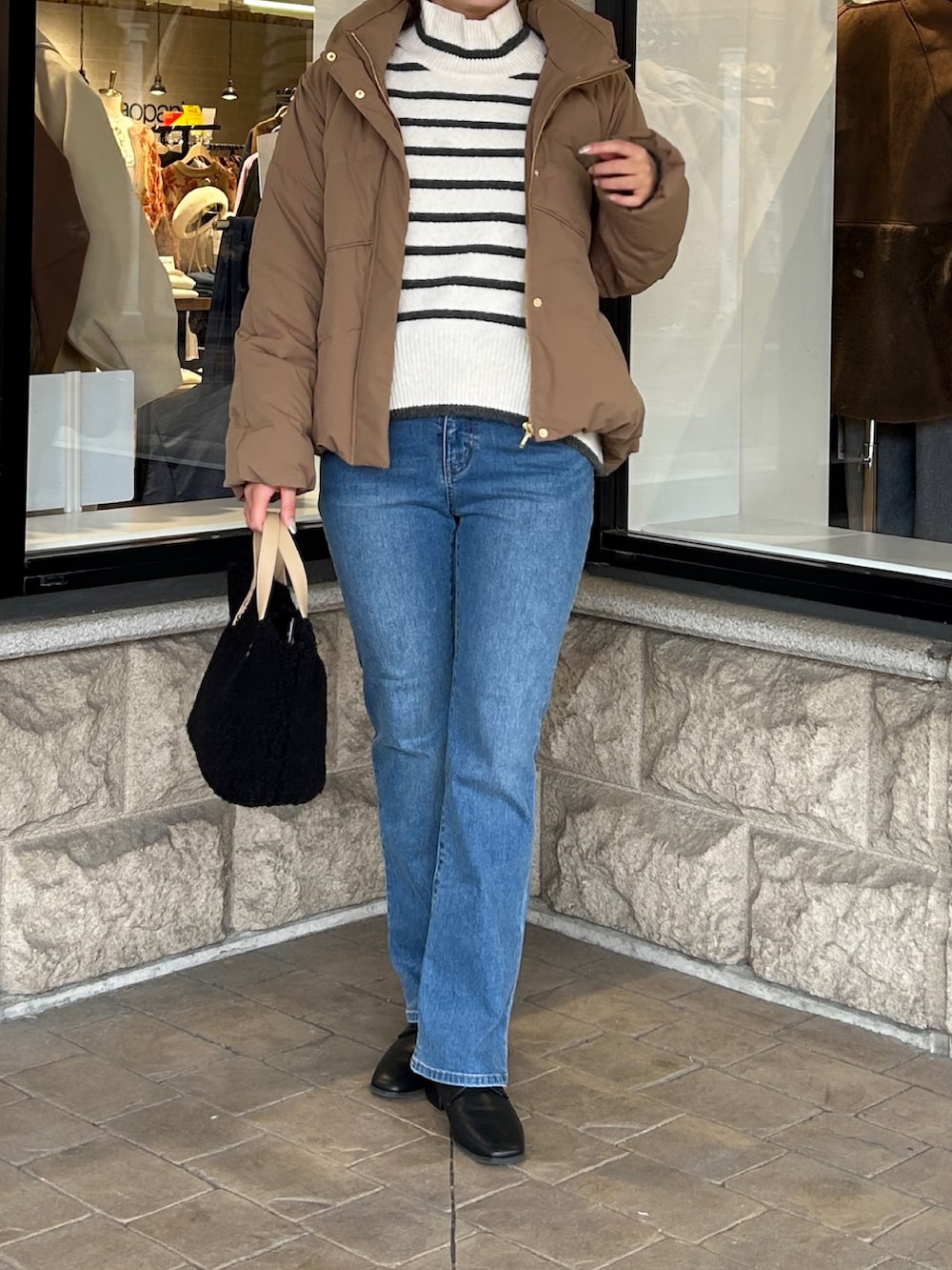 ホワイト系のニット/セーター、ブルー系のデニムパンツ、ブラック系のブーツを着用したレディースの冬コーディネートの4枚目の写真