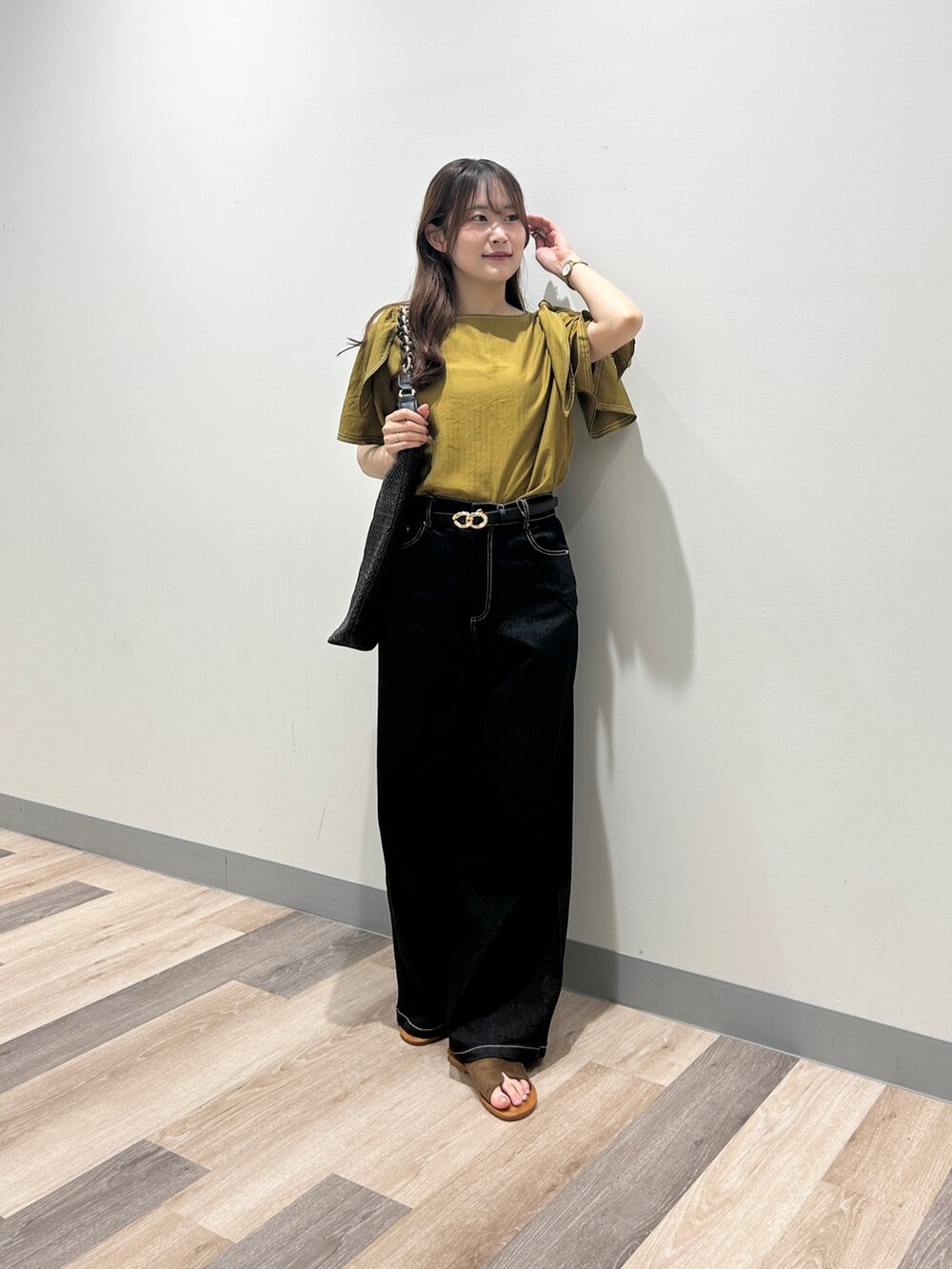 ゴールド系のシャツ/ブラウス、ブラック系のデニムパンツ、ブラウン系のサンダルを着用したレディースの夏コーディネートの4枚目の写真