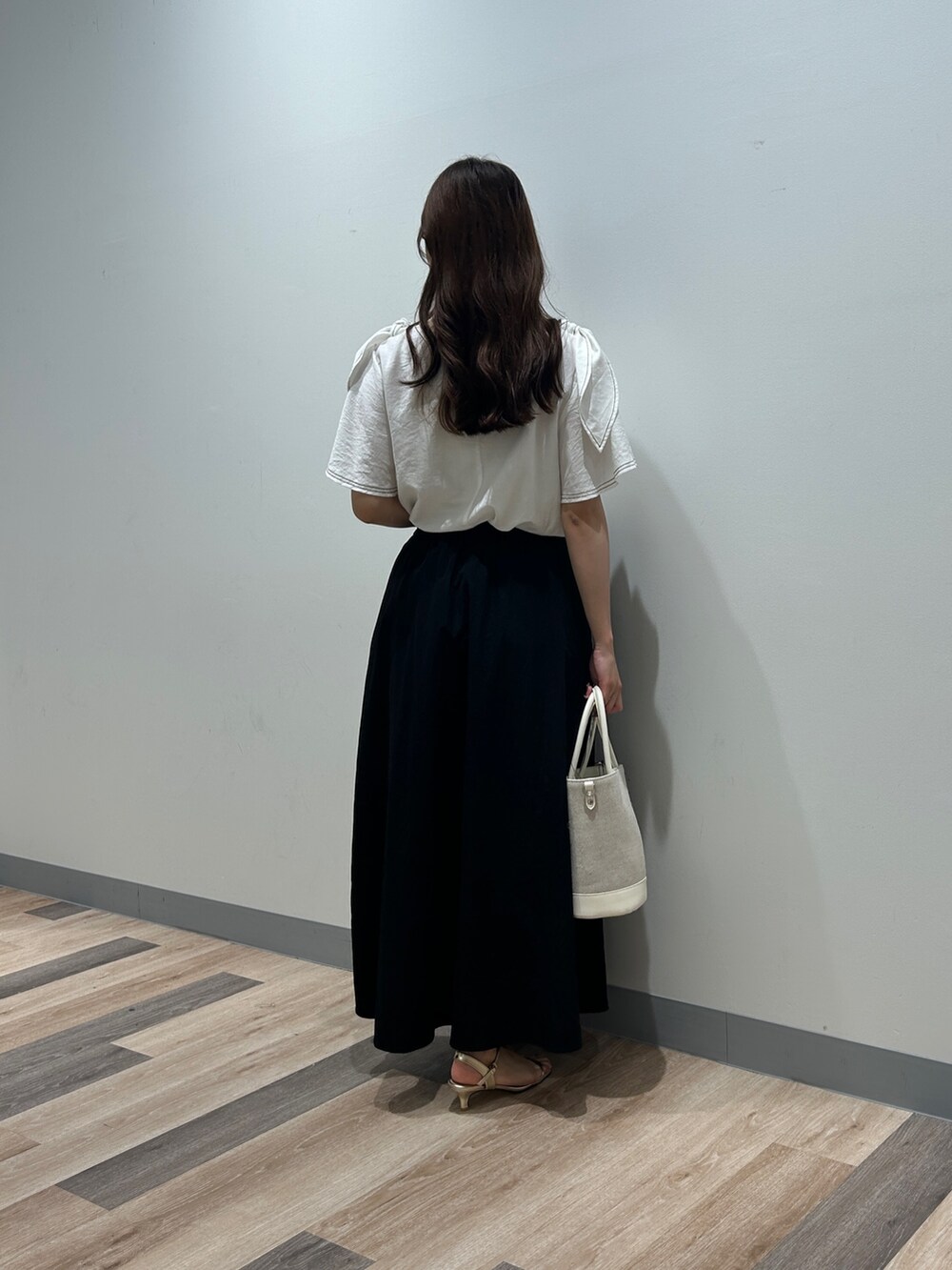 ホワイト系のシャツ/ブラウス、ブラック系のワンピース、ゴールド系のサンダルを着用したレディースの夏コーディネートの3枚目の写真