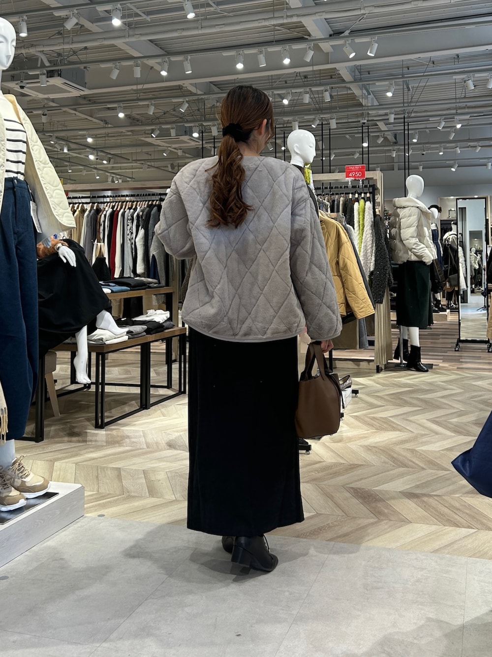 ホワイト系のニット/セーター、ベージュ系のブルゾン、グレー系のスカートを着用したレディースの冬コーディネートの3枚目の写真