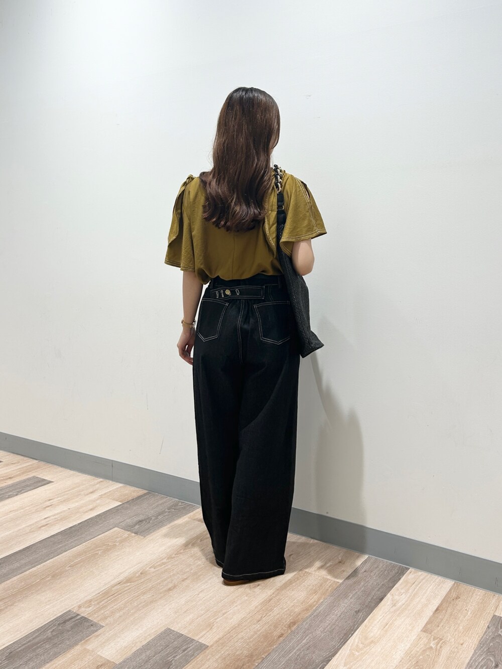 ゴールド系のシャツ/ブラウス、ブラック系のデニムパンツ、ブラウン系のサンダルを着用したレディースの夏コーディネートの2枚目の写真