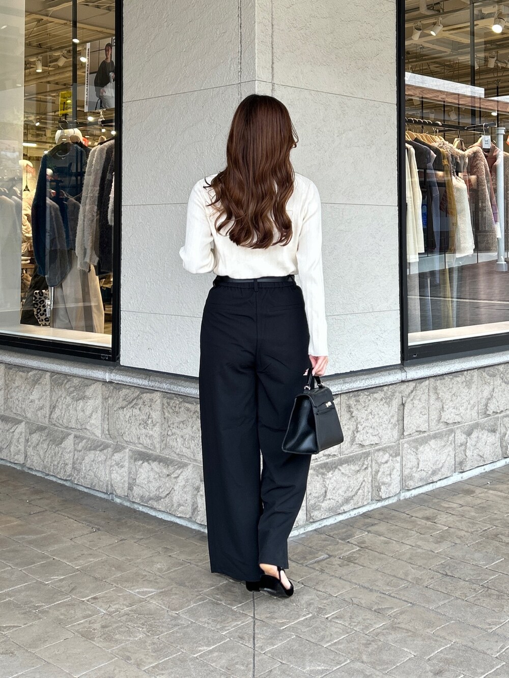 ホワイト系のニット/セーター、ブラック系のその他パンツ、ブラック系のパンプスを着用したレディースの秋コーディネートの3枚目の写真