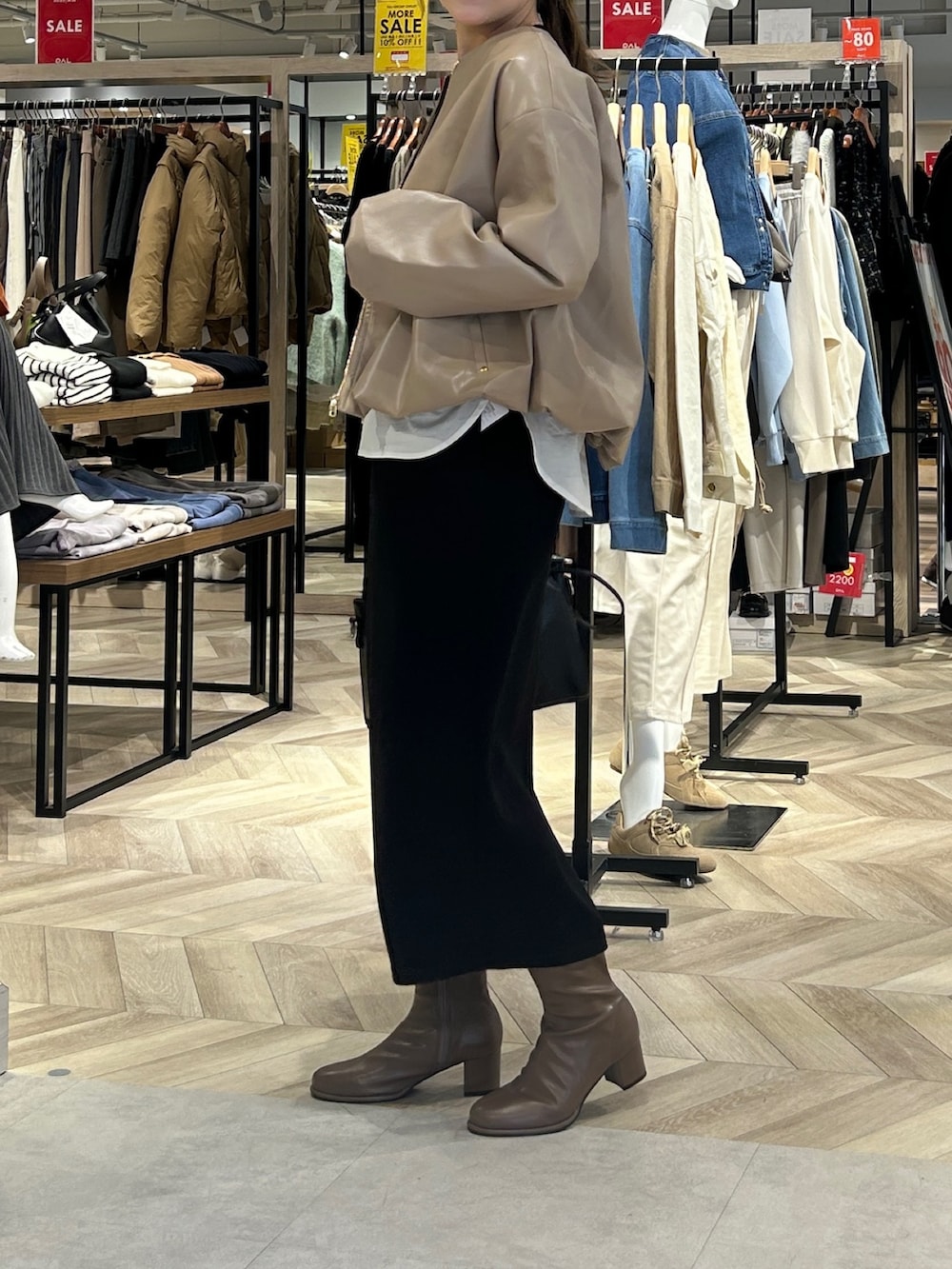 ブラック系のつなぎ/オールインワン、ブラック系のショルダーバッグ、ブラウン系のブーツを着用したレディースの冬コーディネートの2枚目の写真