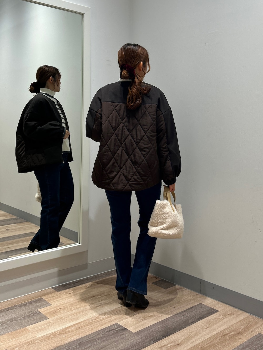 ホワイト系のニット/セーター、ブルー系のデニムパンツ、ブラック系のブーツを着用したレディースの秋コーディネートの3枚目の写真