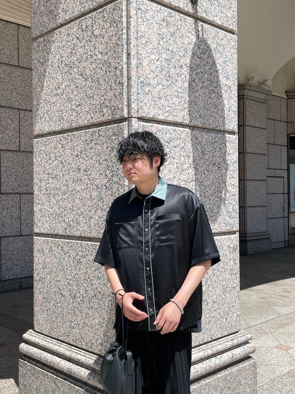 「オールブラック、クレリックシャツ、ショルダーバッグ、巾着バッグ、プリーツパンツ、ビーチサンダル、ビーサン、ワイドパンツ、ビッグシルエット、黒シャツ、半袖シャツ」｜「Lui'sの【Neucon / ニューコン】23SS クレリックパイピングシャツ（シャツ/ブラウス、ブラック系）」を使った、Shu ⠀Iizukaさん（メンズ・187cm）の夏コーディネートの2枚目の写真
