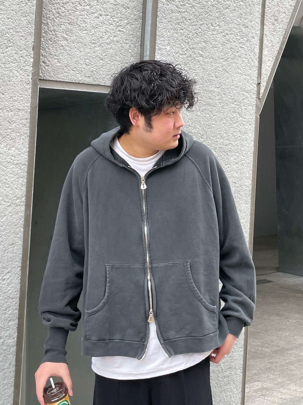 ブラック系のトップス、ホワイト系のTシャツ/カットソー、ブラック系のスラックスを着用したメンズの春コーディネートの2枚目の写真