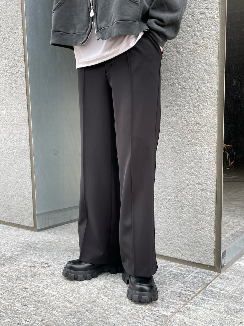 ブラック系のトップス、ホワイト系のTシャツ/カットソー、ブラック系のスラックスを着用したメンズの春コーディネートの3枚目の写真