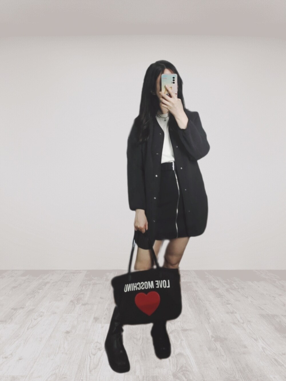 ブラック系のスカート、ブラック系のトートバッグ、ブラック系のブーツを着用したレディースの冬コーディネートの2枚目の写真