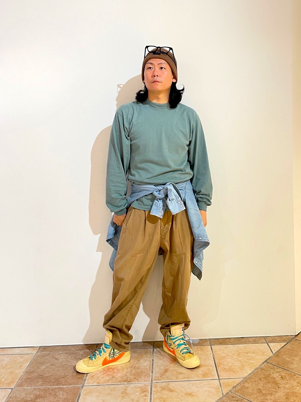 グリーン系のTシャツ/カットソー、ブルー系のシャツ/ブラウス、ベージュ系のチノパンツを着用したメンズの秋コーディネートの2枚目の写真