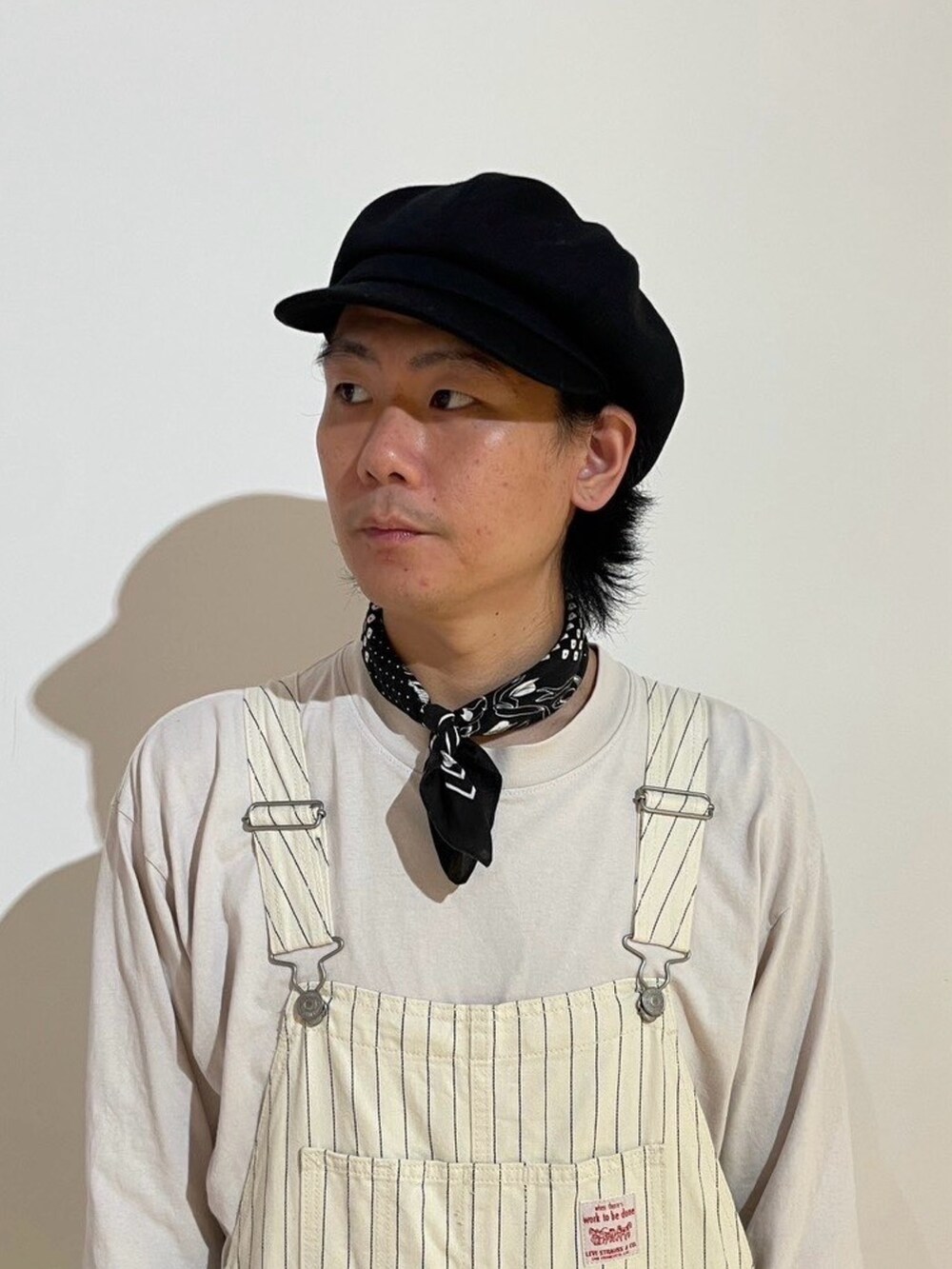 ブラック系のキャスケットを着用したメンズの秋コーディネートの2枚目の写真