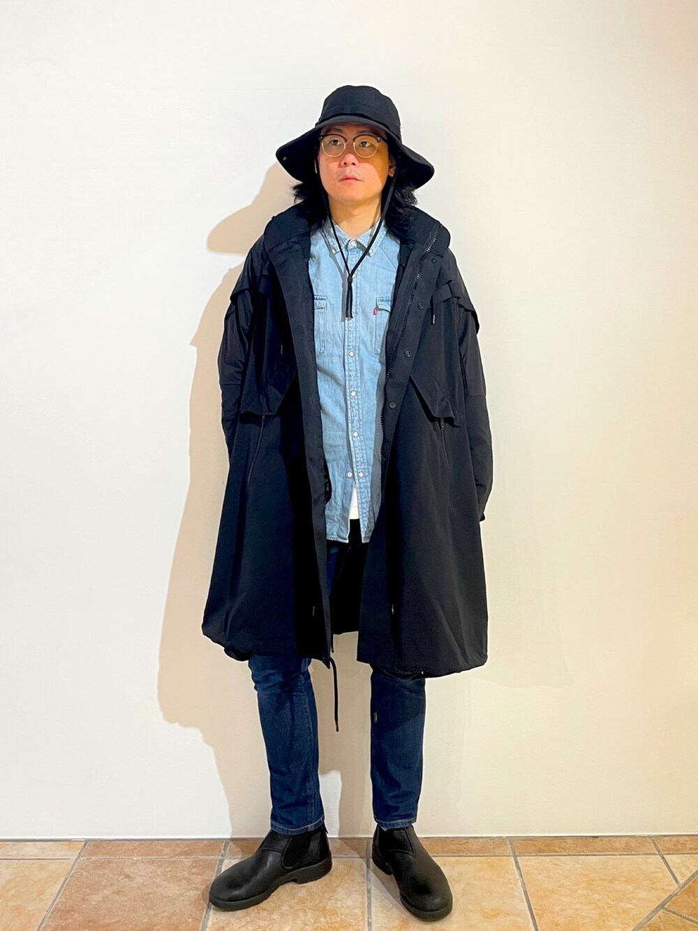 ブルー系のシャツ/ブラウス、ブラック系のブーツ、ブラック系のハットを着用したメンズの春コーディネートの2枚目の写真