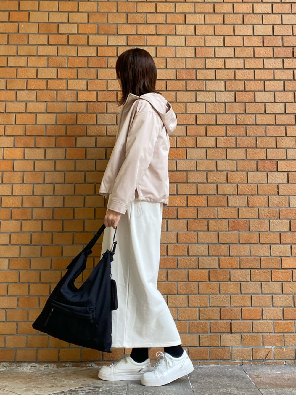 ベージュ系のマウンテンパーカー、ホワイト系のワンピースを着用したレディースの冬コーディネートの3枚目の写真