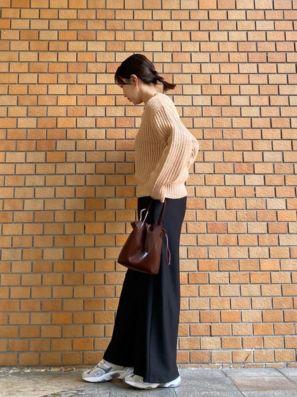 ピンク系のニット/セーター、ブラック系のその他パンツを着用したレディースの冬コーディネートの2枚目の写真