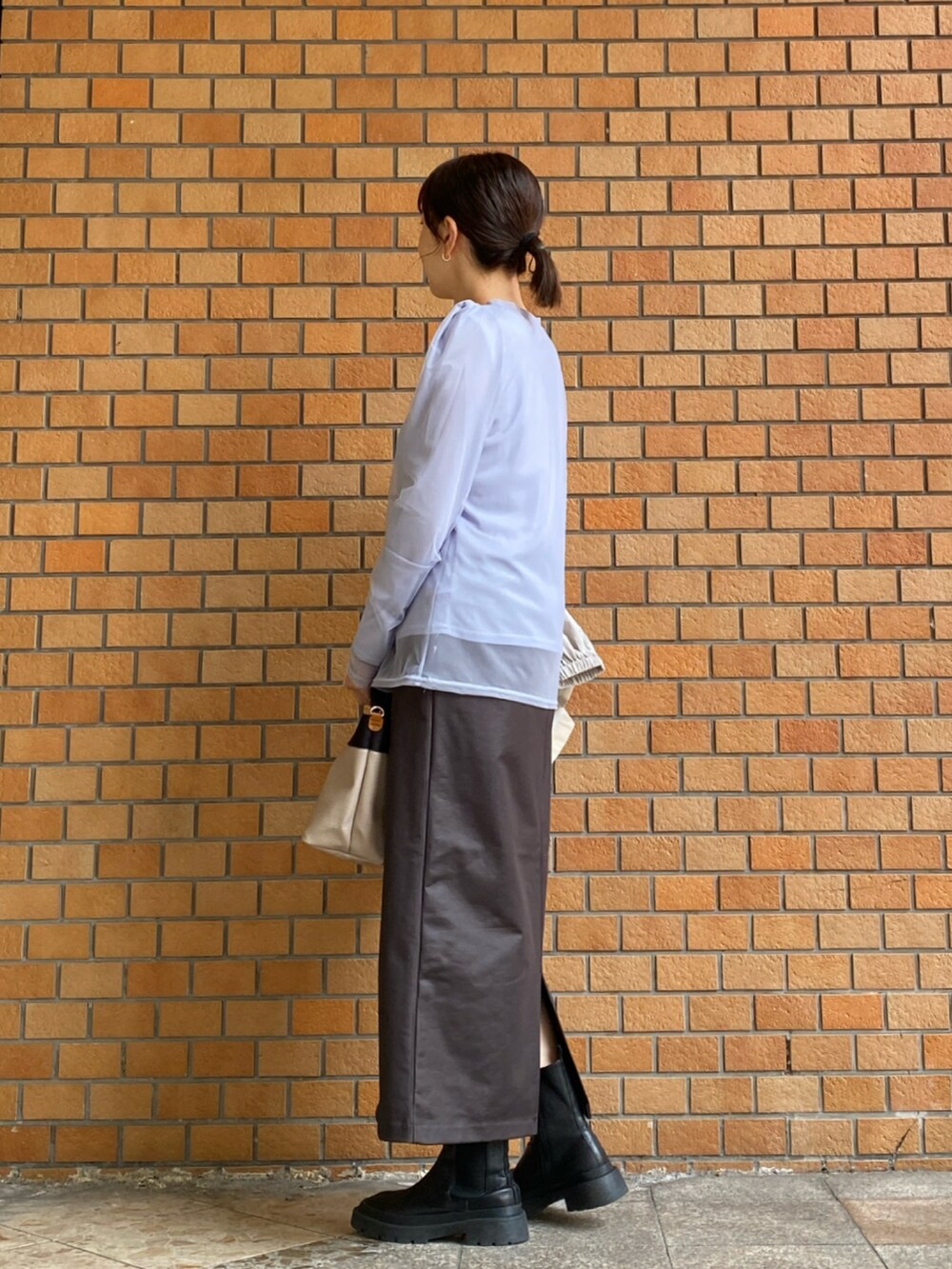 ブルー系のTシャツ/カットソー、ブラウン系のスカート、ベージュ系のマウンテンパーカーを着用したレディースの秋コーディネートの4枚目の写真