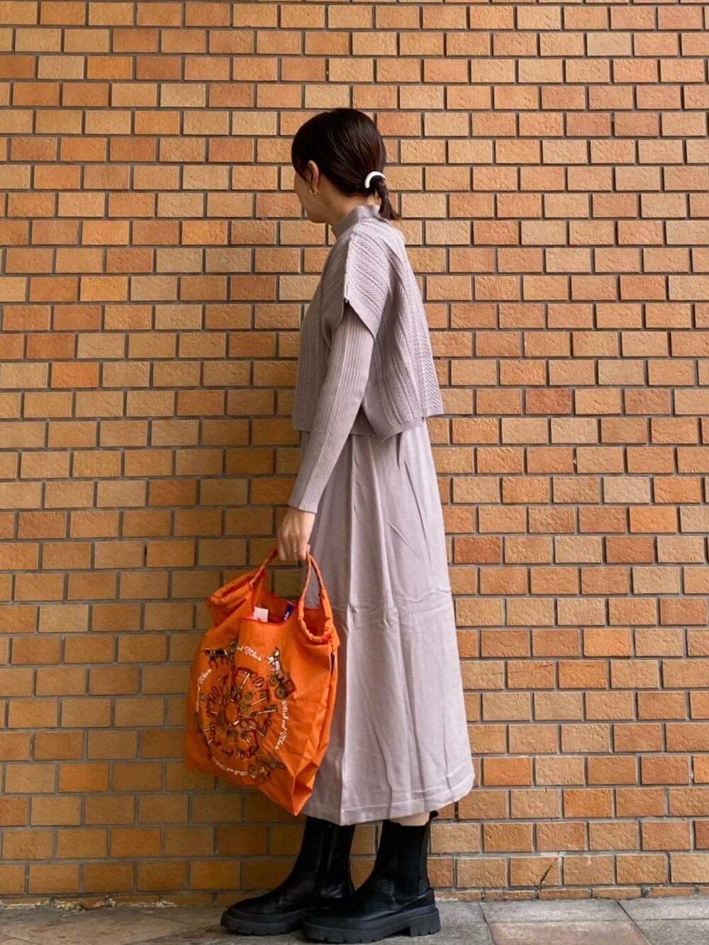 ベージュ系のワンピースを着用したレディースの秋コーディネートの2枚目の写真