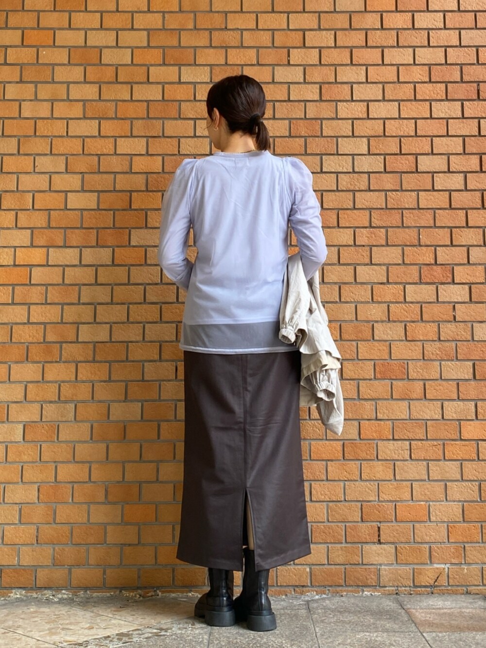 ブルー系のTシャツ/カットソー、ブラウン系のスカート、ベージュ系のマウンテンパーカーを着用したレディースの秋コーディネートの5枚目の写真